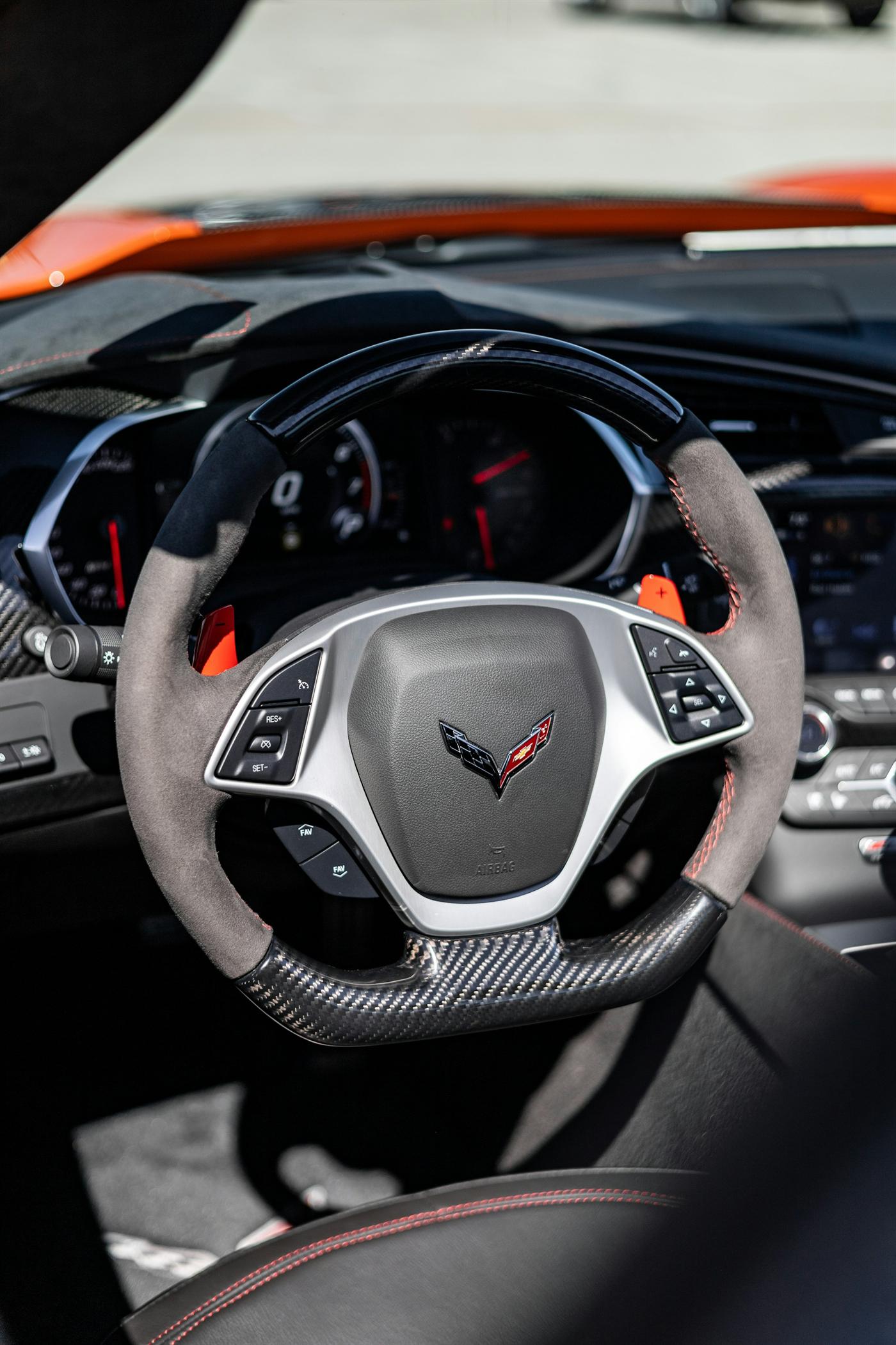 Alcantara and carbon fibre steering wheel in a sports car cockpit