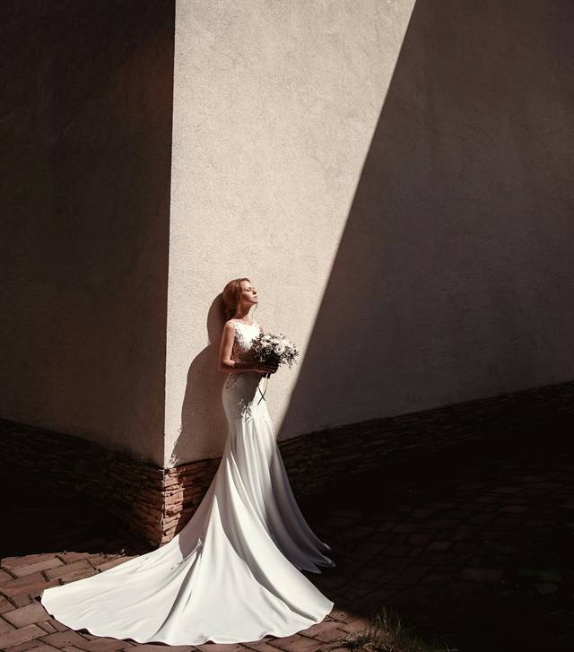 A bride against a sunlit wall