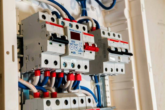 A newly installed distribution board with blue jumper wiring and red terminals