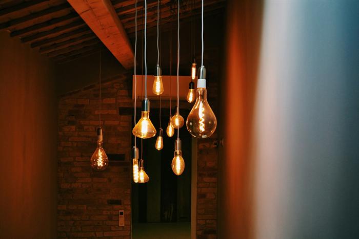 Warm filament pendant lights hanging from a beamed ceiling in a restaurant