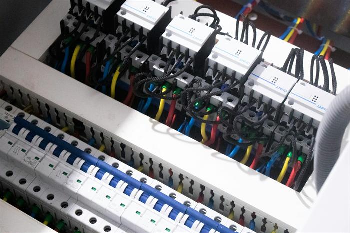 Rows of miniature circuit breakers and coloured wiring inside a switchboard